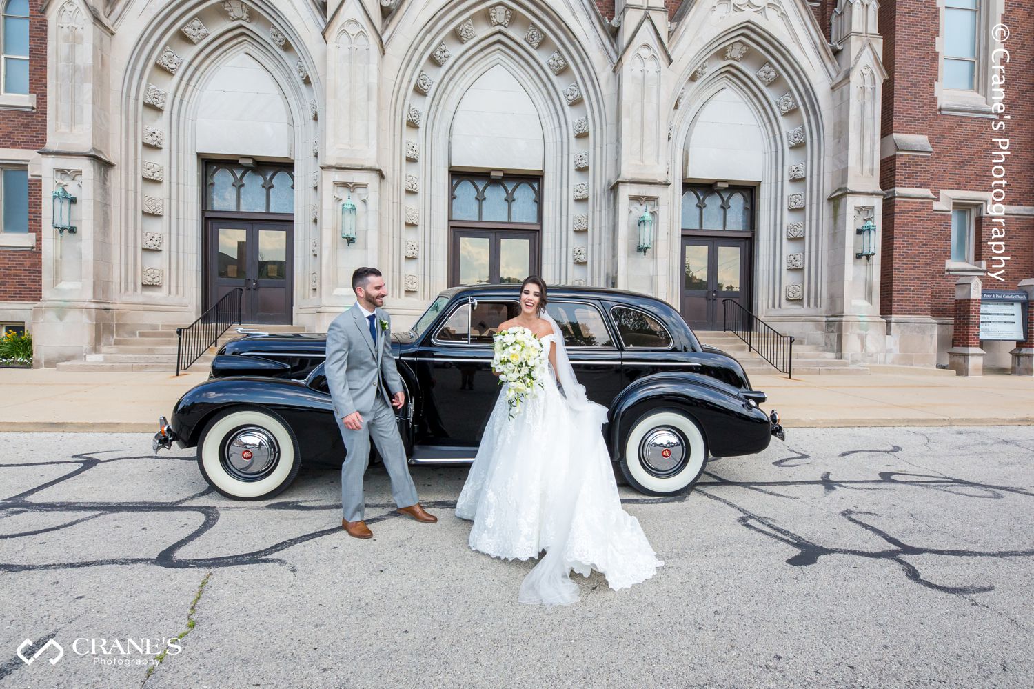 A fun moment between a bride and groom in front of St. Peter and Paul Church in Naperville