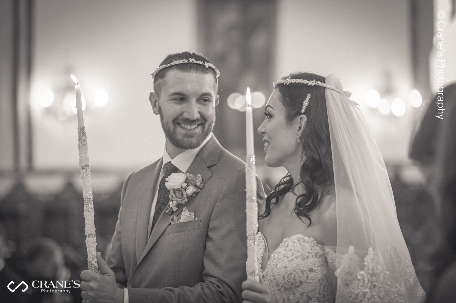 Black and white photo of a bride and groom with their traditional greek orthodox wedding crowns.