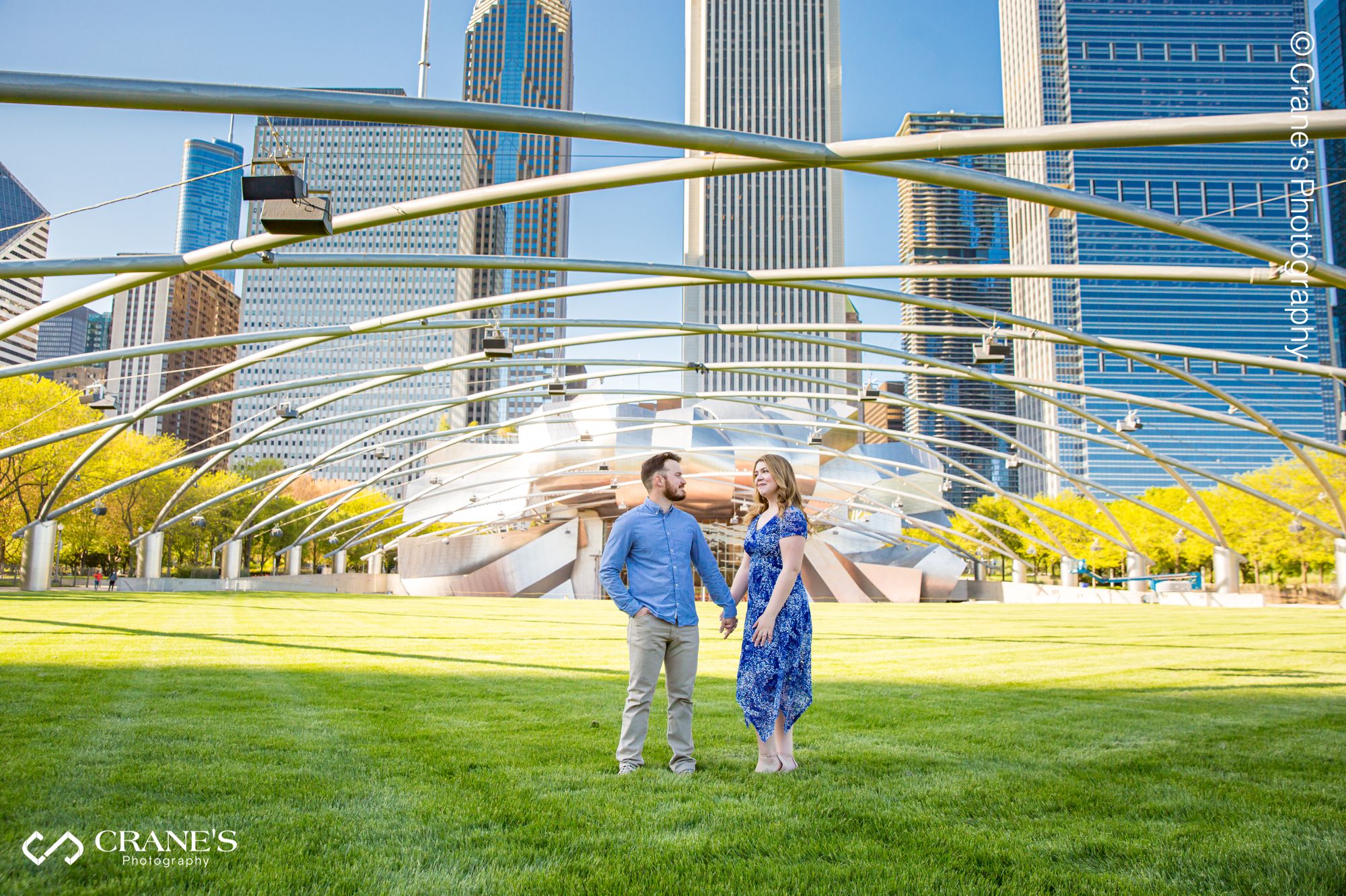A wide angle image of an engaged couple at Jay Pritzker Pavilion & The Great Lawn