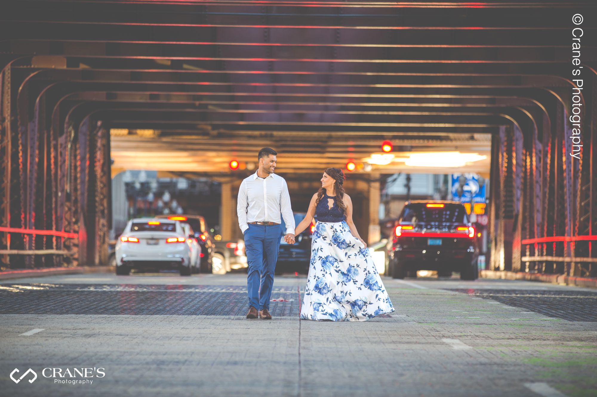 Downtown Chicago river bridge engagement session photo of a couple walking on the street