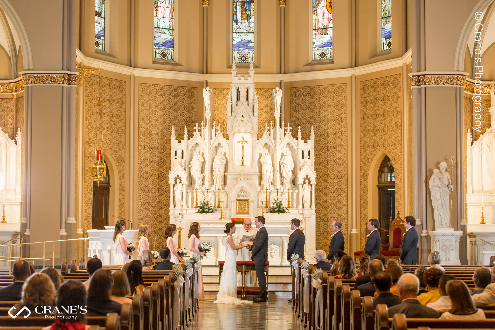 Bride and groom exchange rings at their Our Lady of Mount Carmel Chicago wedding