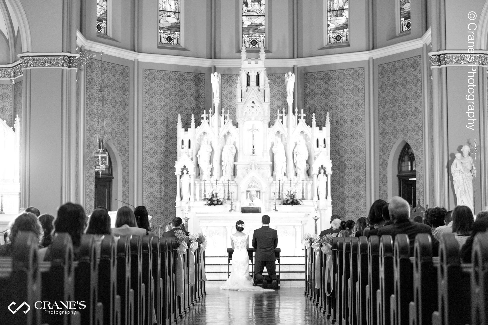 A black and white photo of a bride and groom at the altar of Our Lady of Mount Carmel Chicago
