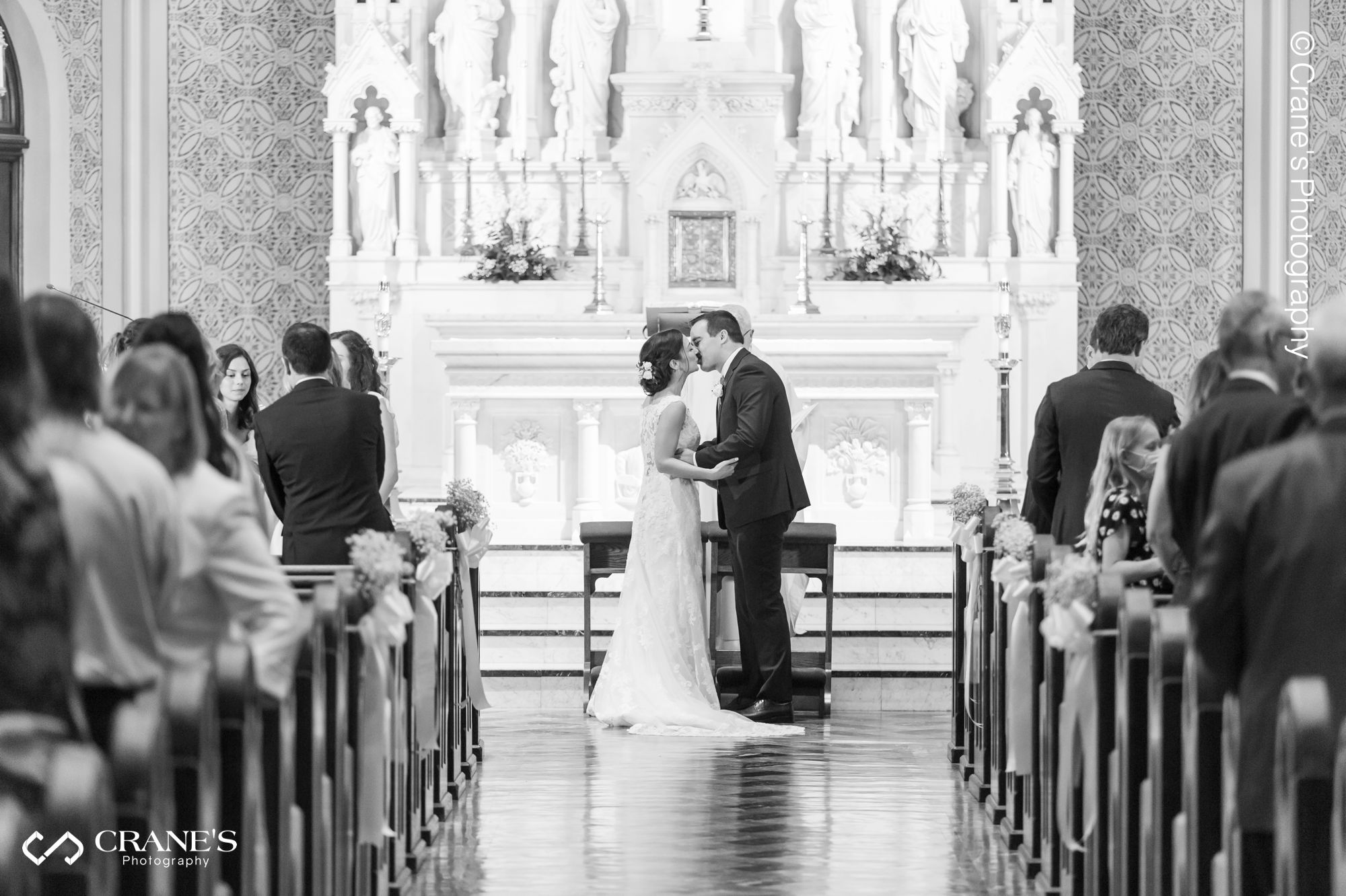 Bride and groom's first kiss at their wedding ceremony at Our Lady of Mount Carmel Chicago