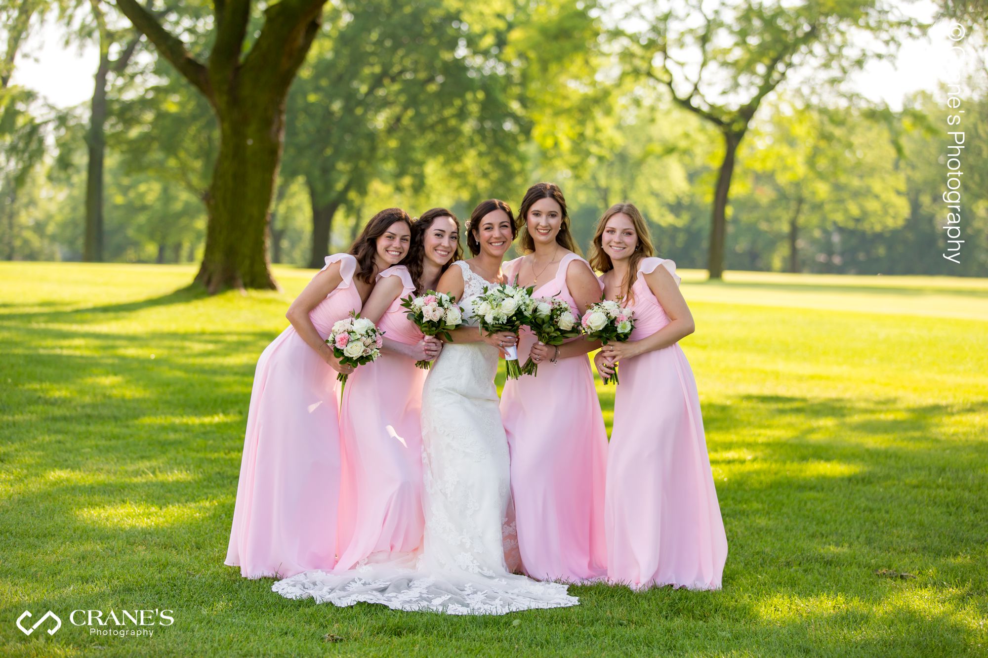 Bridesmaids wearing pink dresses pose for a photo at La Grange Country Club