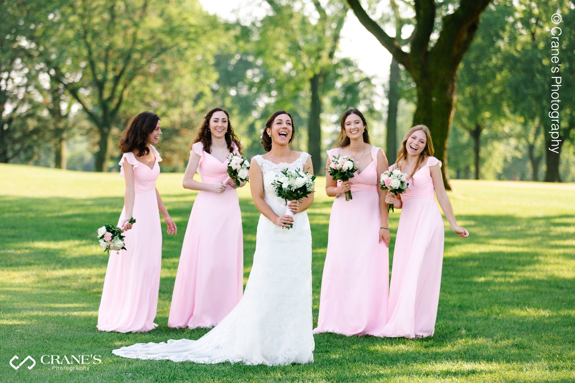 Bride laughing with her bridesmaids in the background at La Grange Country Club