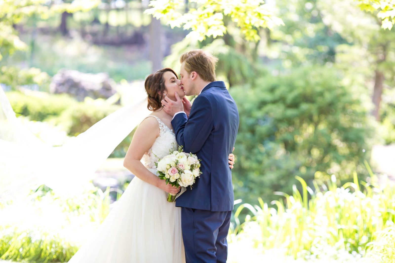 A posed image of a bride and groom kissing at Fabyan Japanese Garden