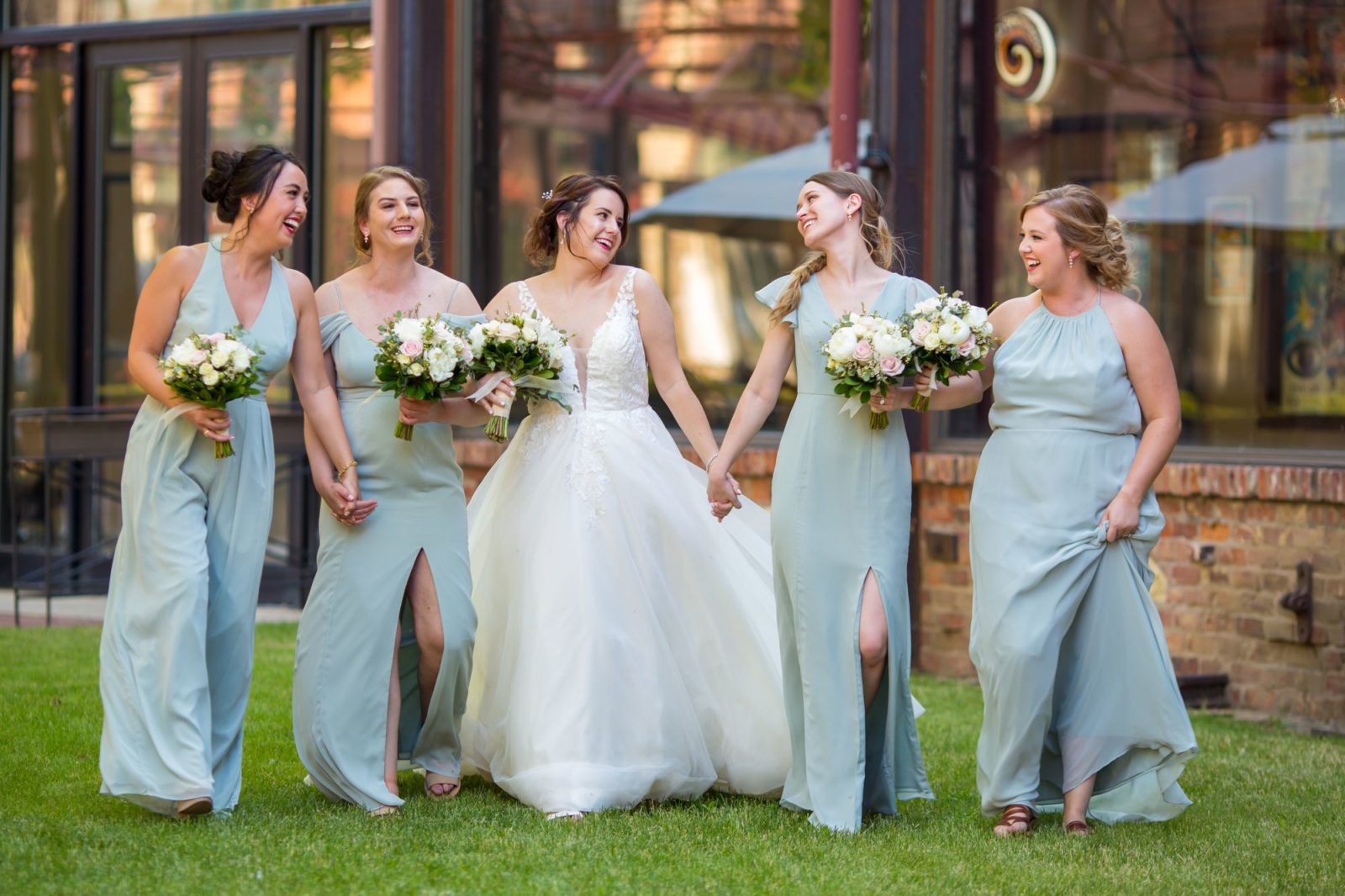 Bridesmaids walking hand in hand at Two Brother's Roundhouse