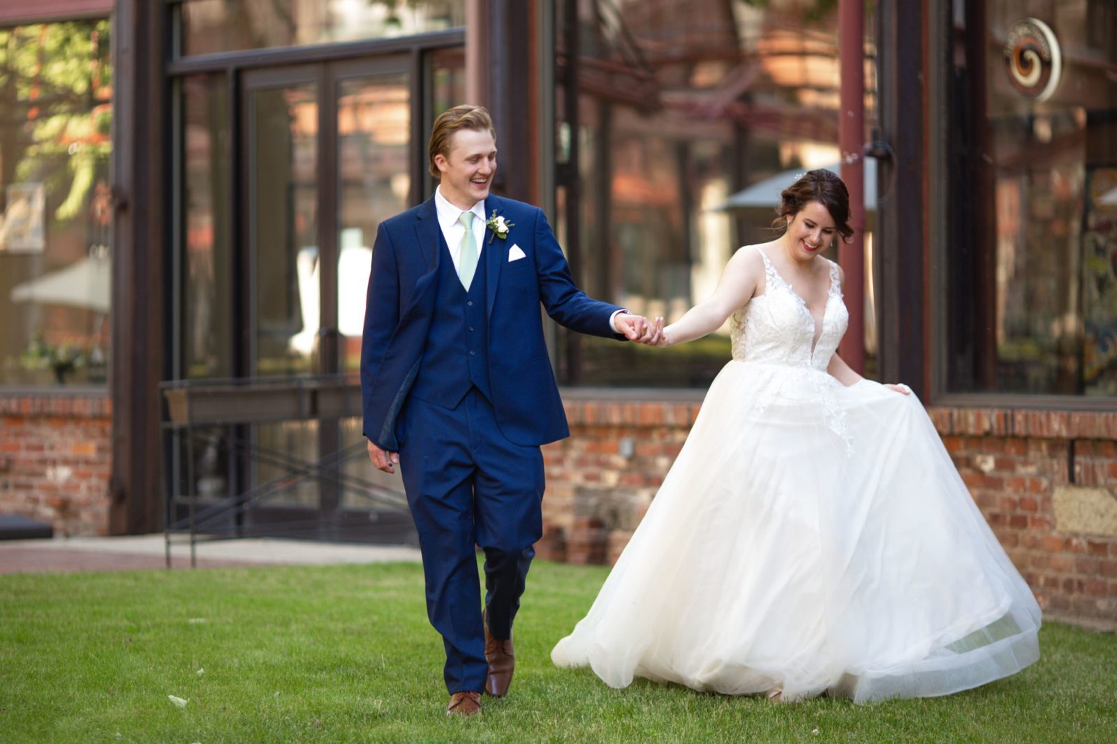 Bride and groom smiling while walking at Two Brother's Roundhouse