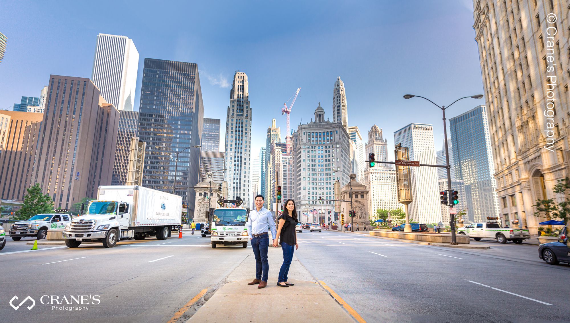 A panoramic engagement photo of the skyline of Chicago in front of Wrigley Building