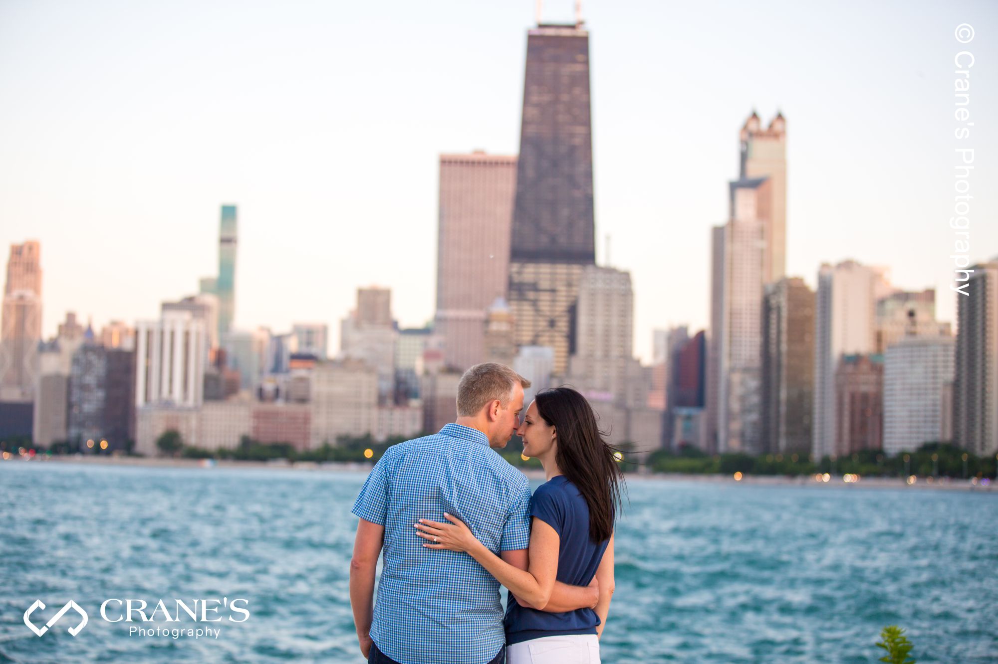 A Summer Chicago engagement session photo taken near the lake with the skyline in the background