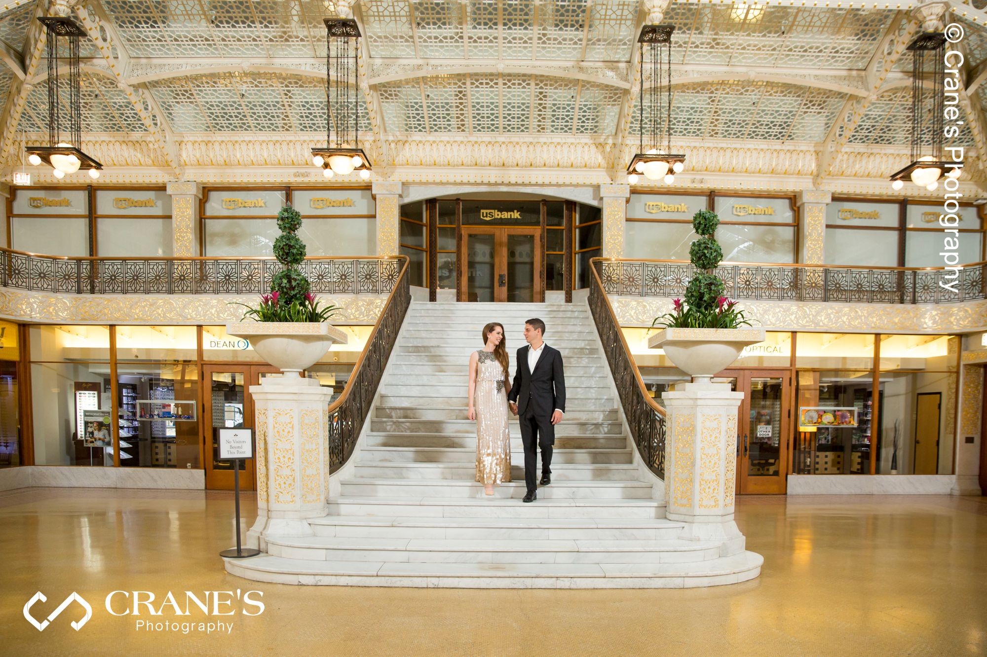 A couple walking hand in hand at the Grand Staircase at The Rookery in Chicago