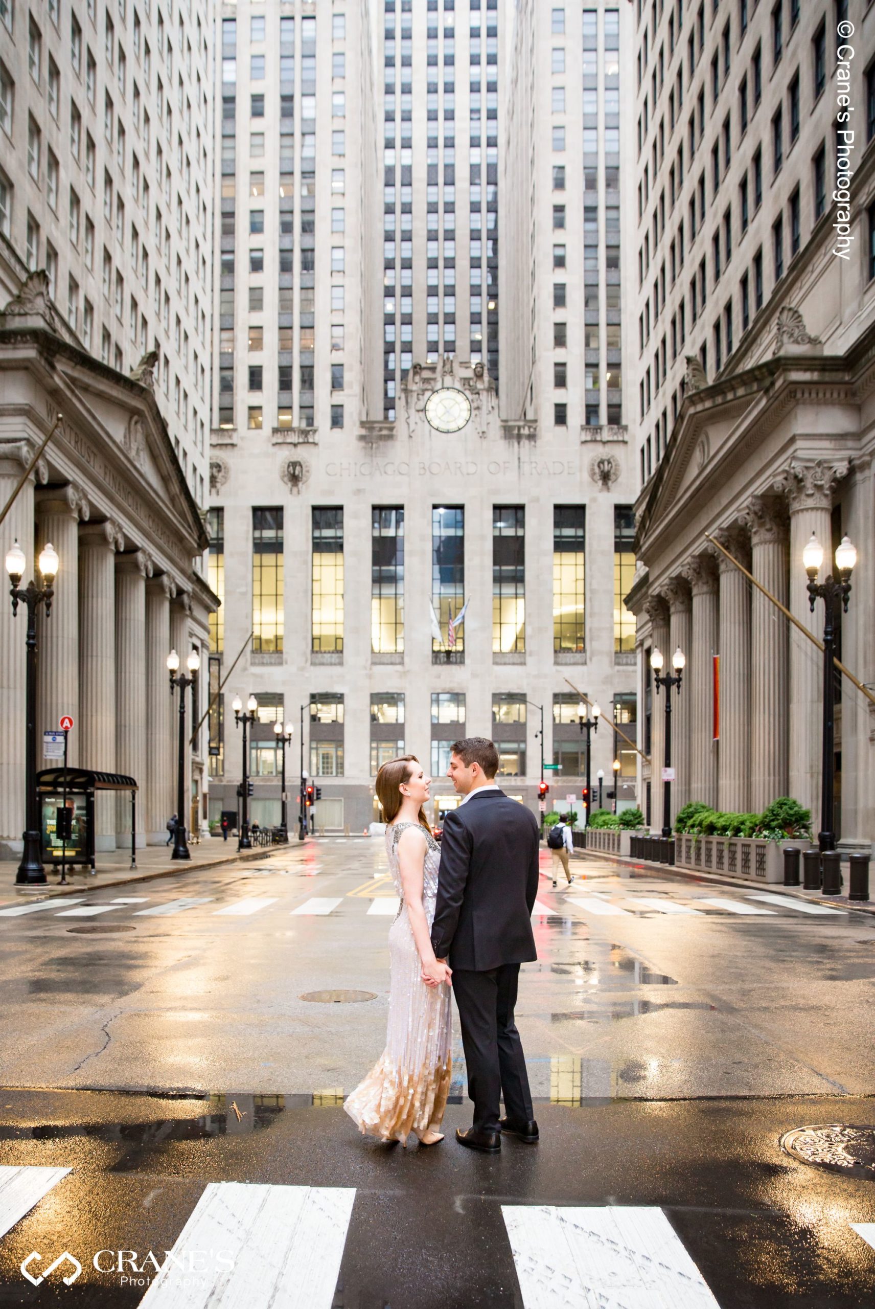 Chicago Board of Trade Building engagement photo taken just outside The Rookery Building on a rainy day