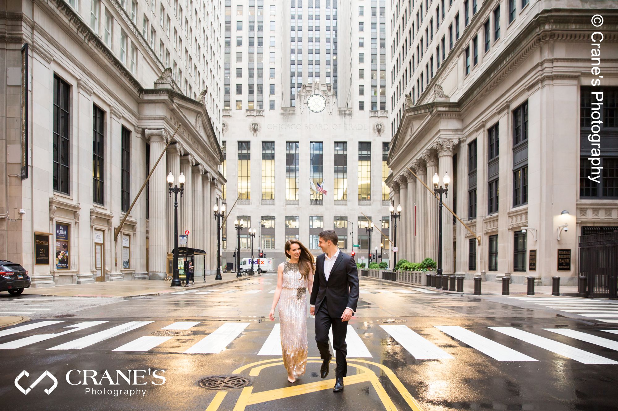 A modern couple pose for a photo in front of the Chicago Board of Trade Building