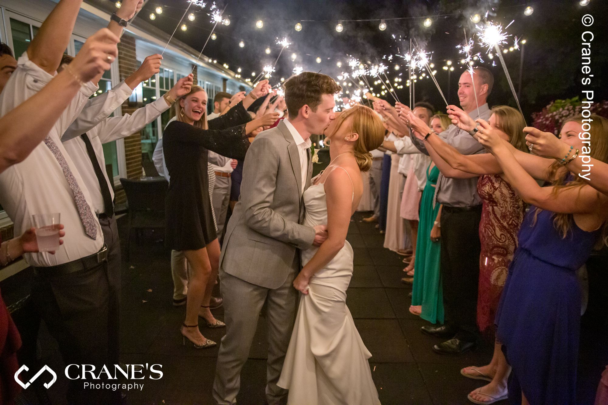 Bride and groom kiss during a sparklers sent-off at Big Foot Country Club