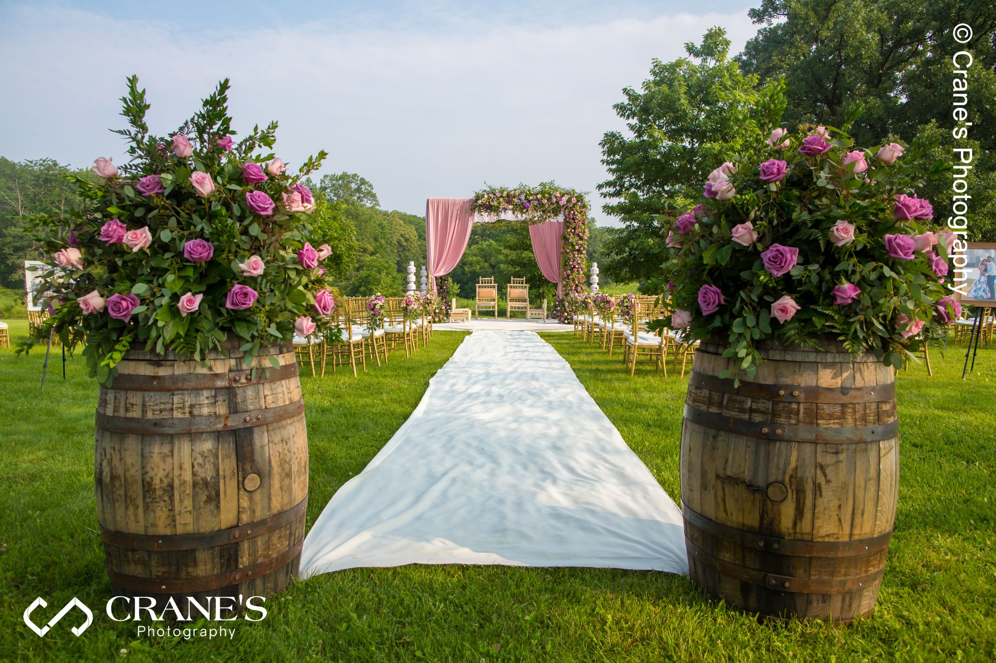 An outdoor Indian wedding mandap decorated with pink linen and flowers.