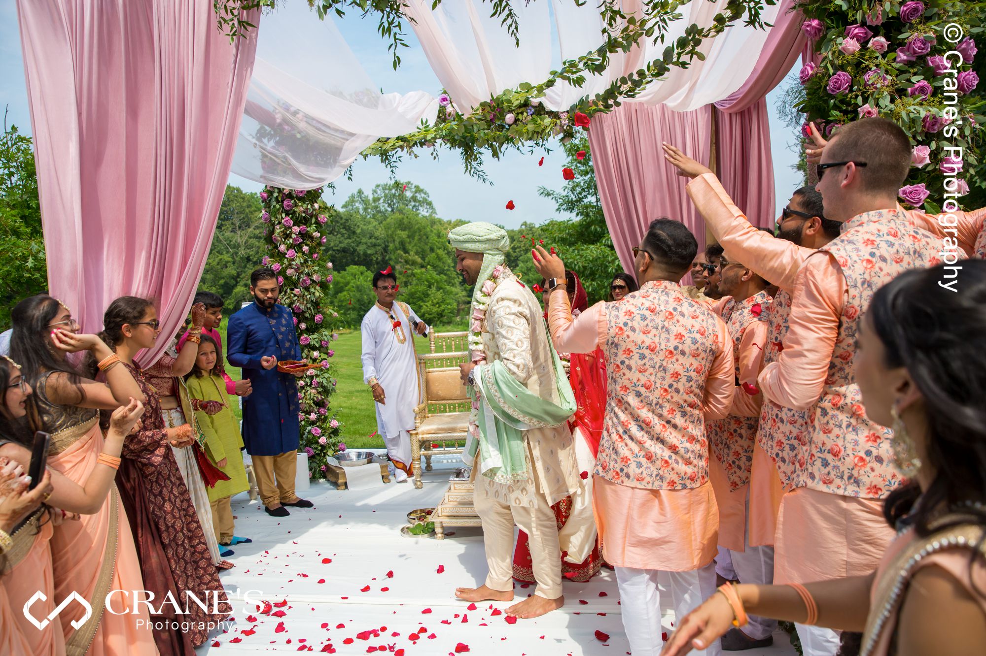 Wedding party and family send blessing to an Indian bride and groom at their outdoor wedding