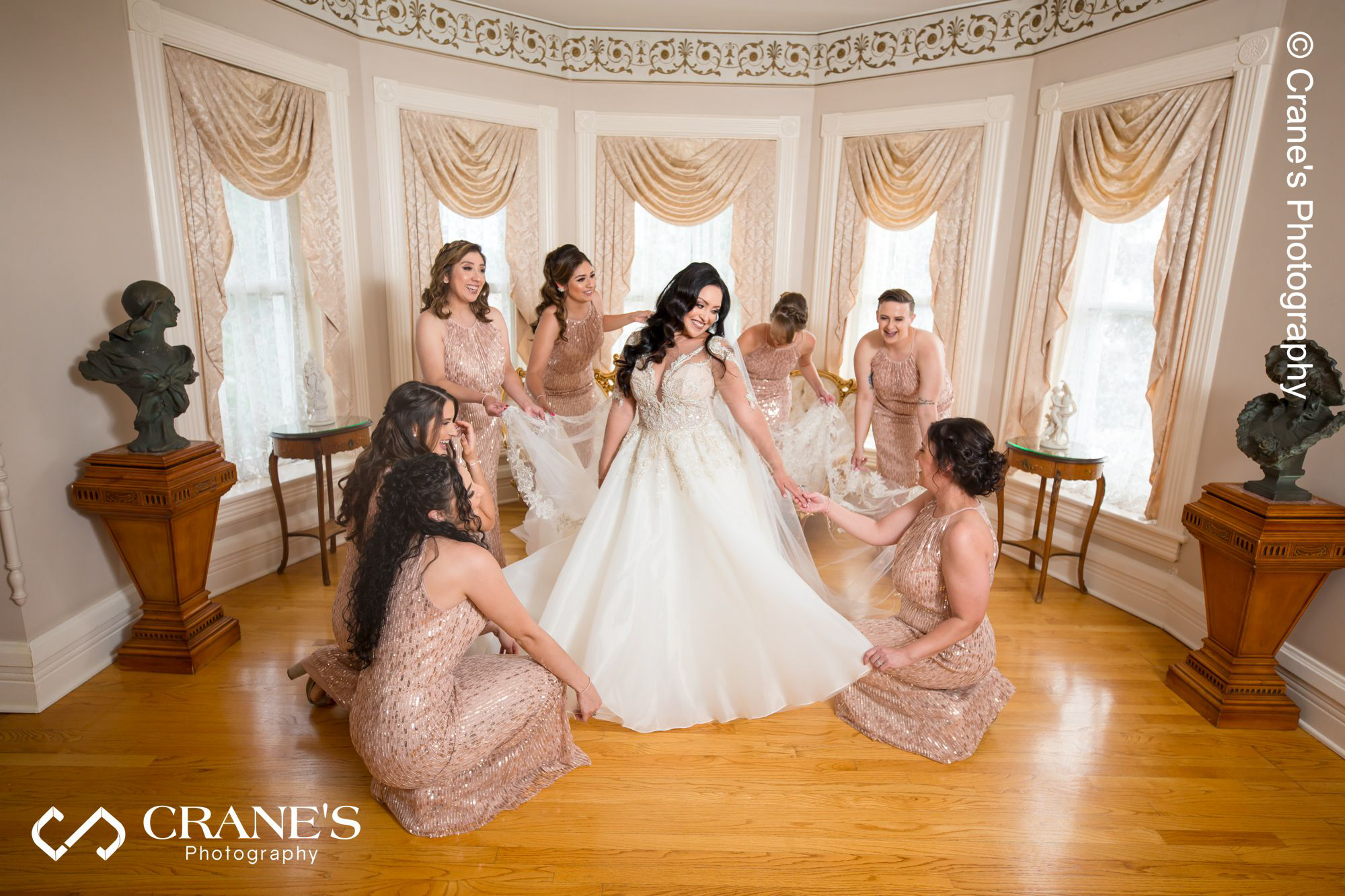Bridesmaids helping the bride getting ready for her wedding at Haley Mansion