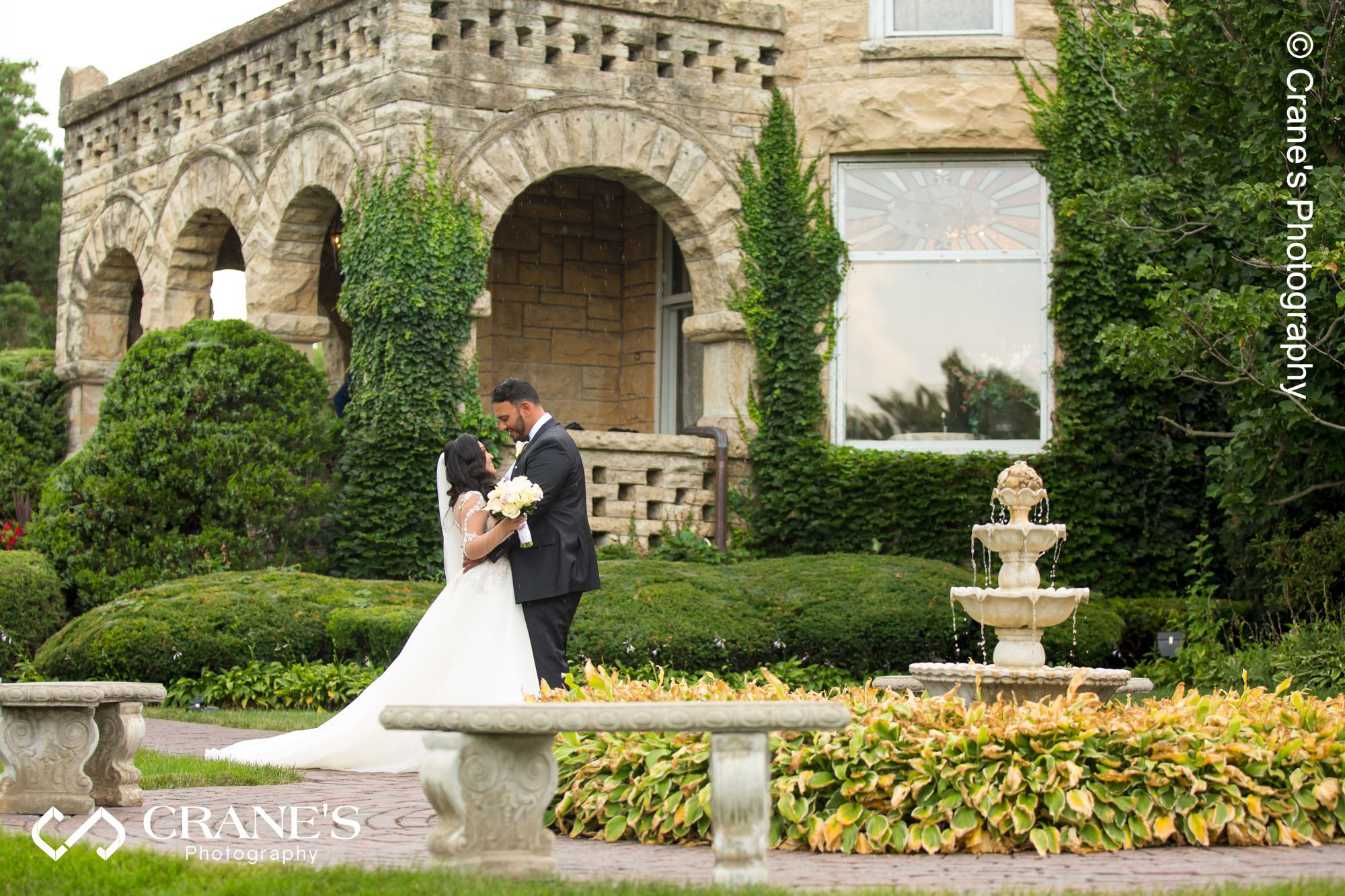 Modern bride and groom wedding photo taken next to the fountain on the front of Haley Mansion