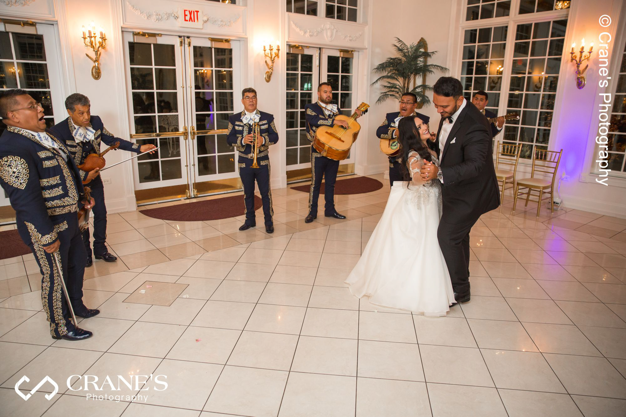 Bride and groom dance in front of a mariachi band at the sophisticated ballroom at the Haley Mansion