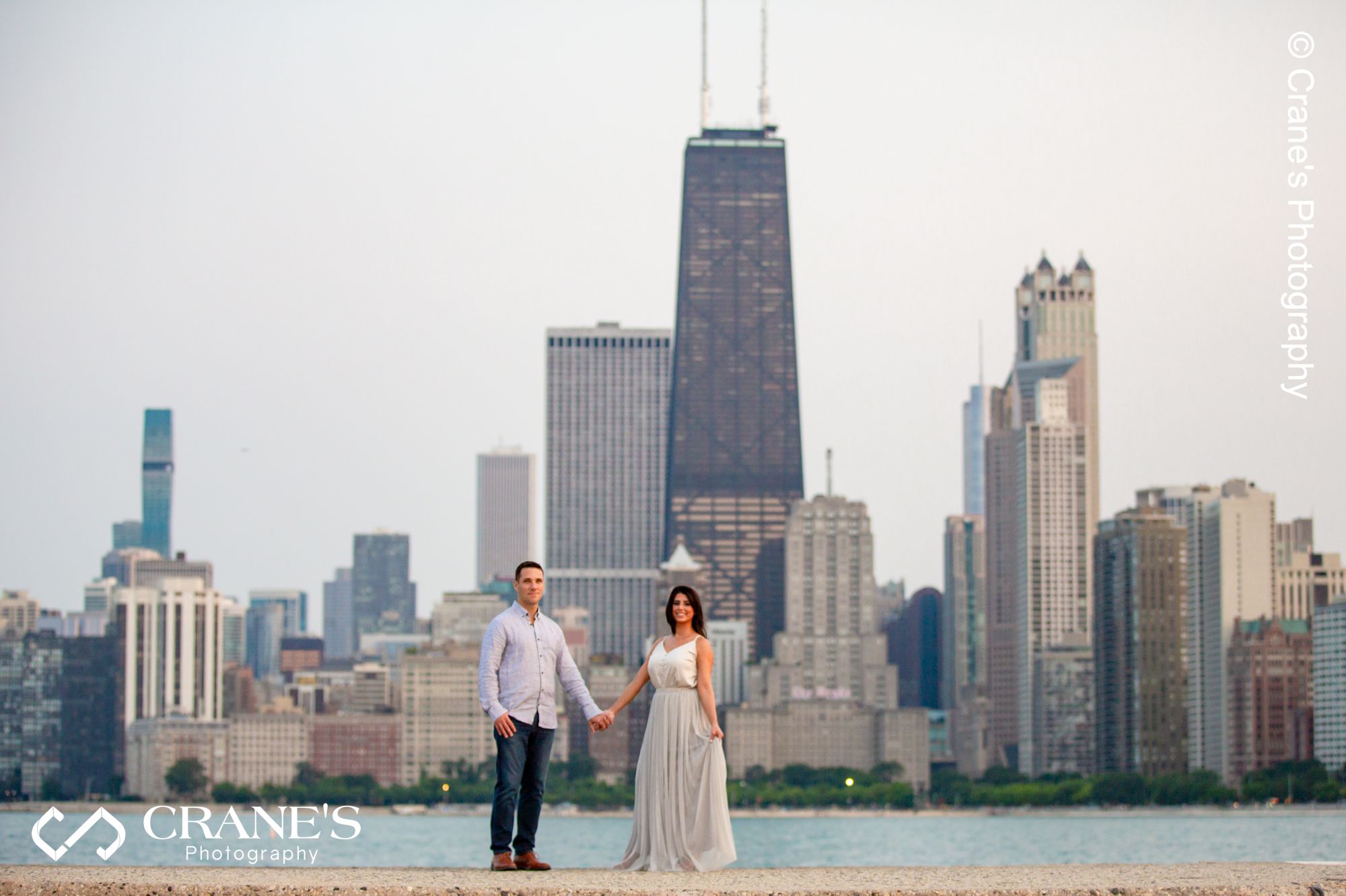 A panoramic engagement session photo taken at North Ave beach with the city in background.
