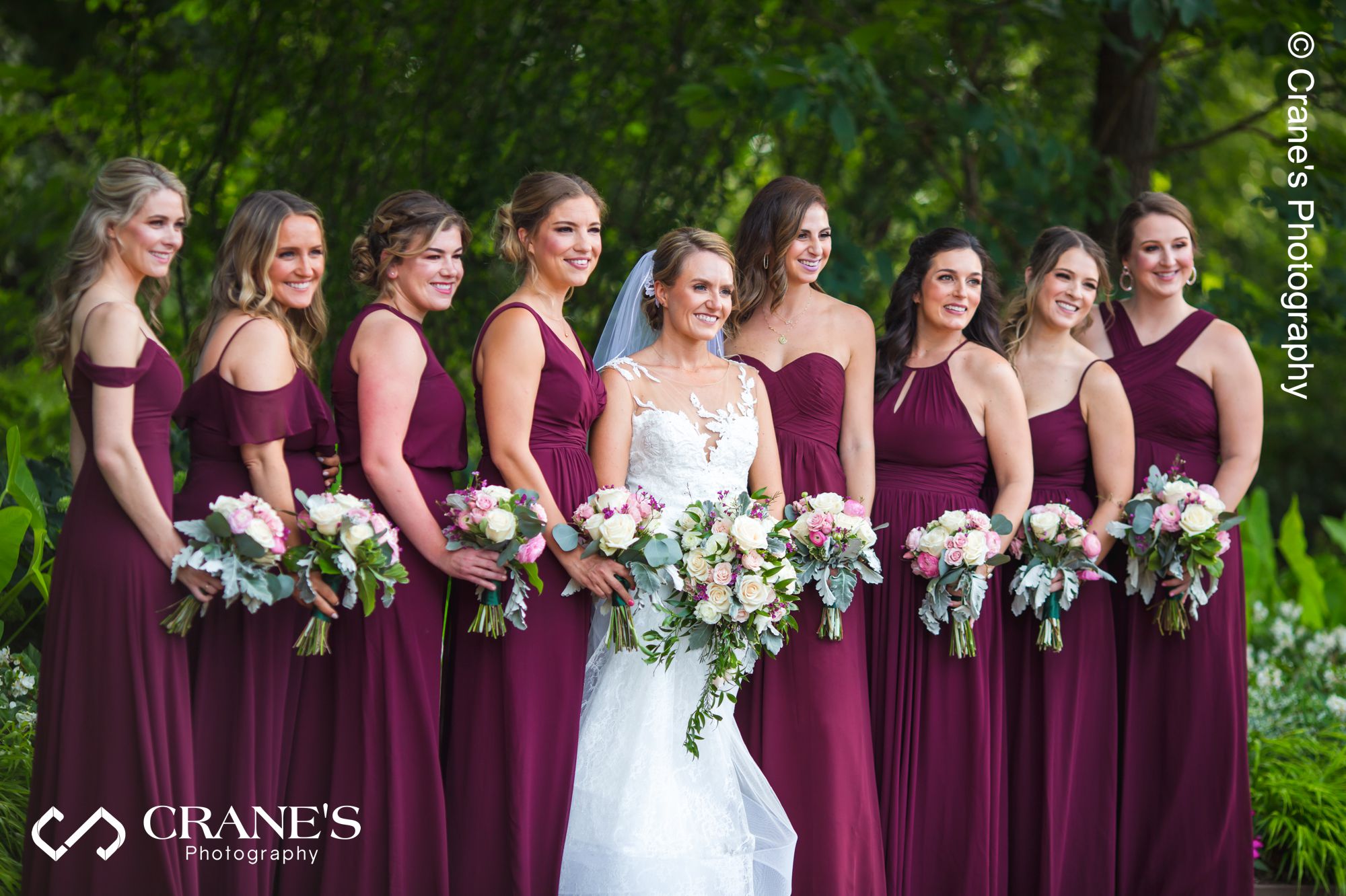 A group wedding photos of bridesmaids wearing purple dresses at the Morton Arboretum