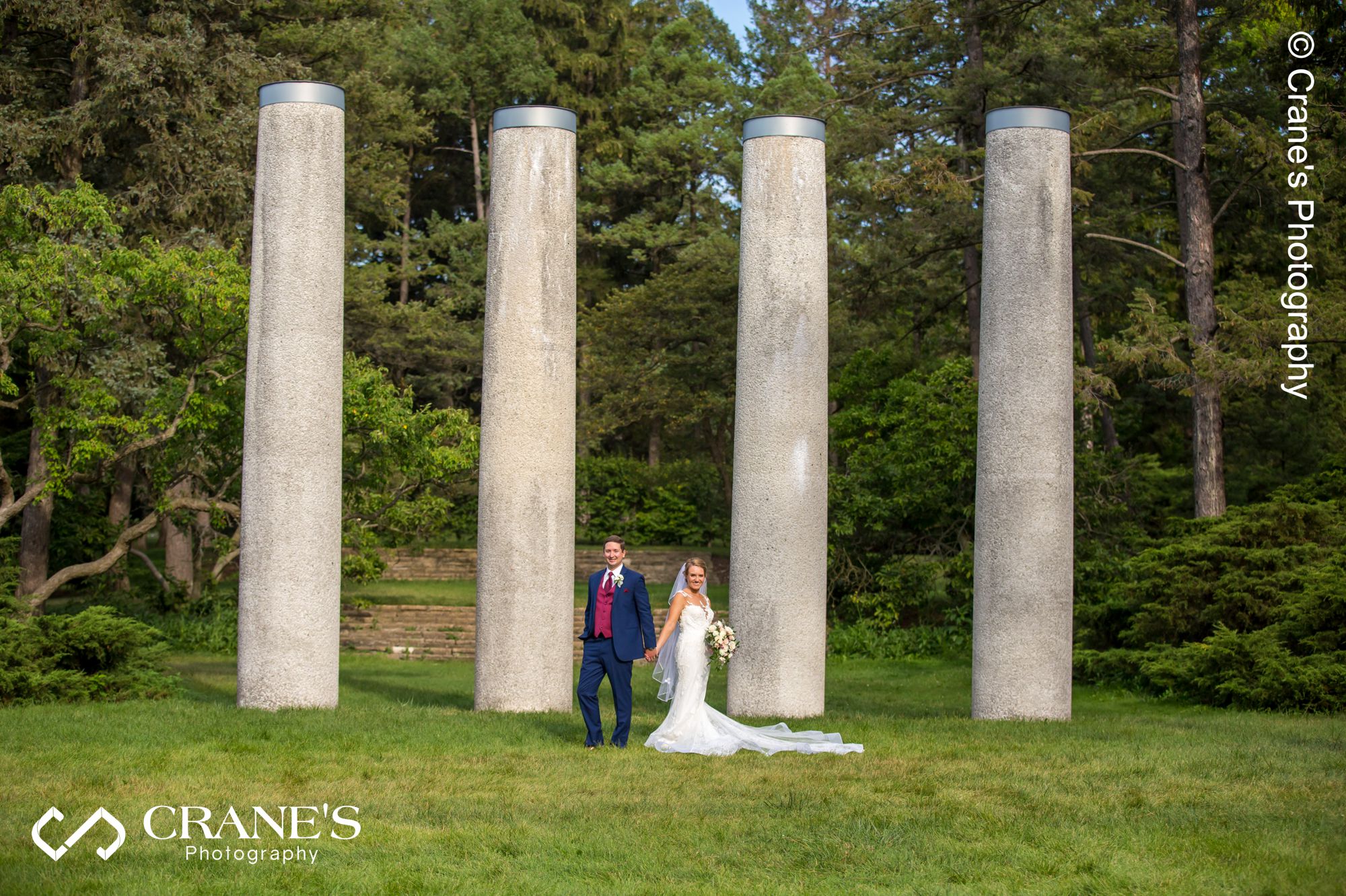 Posed wedding photo with 4 columns in the background at the Morton Arboretum
