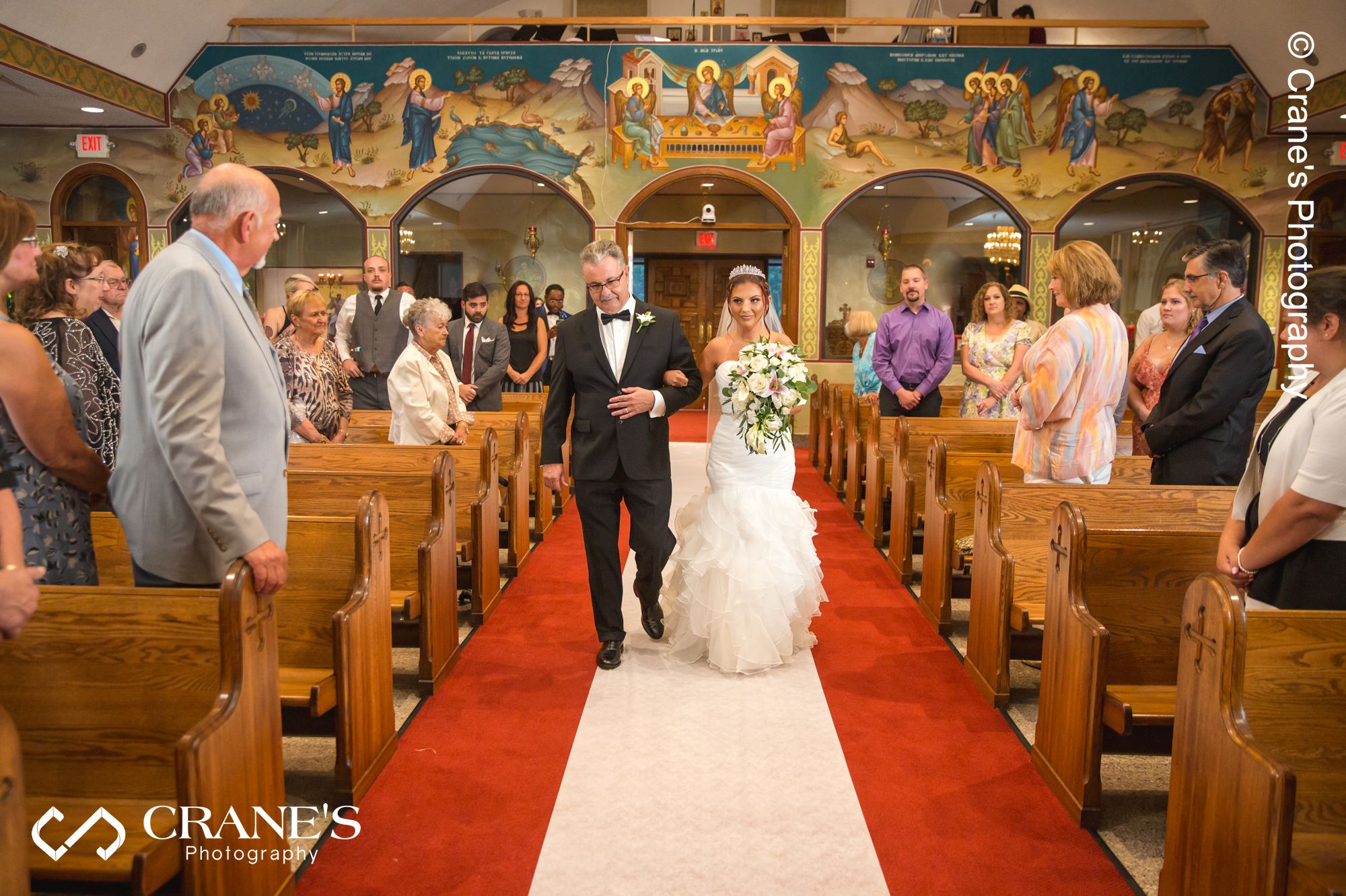 Bride walk down the aisle with her dad at her greek Orthodox wedding at St. Nectarios