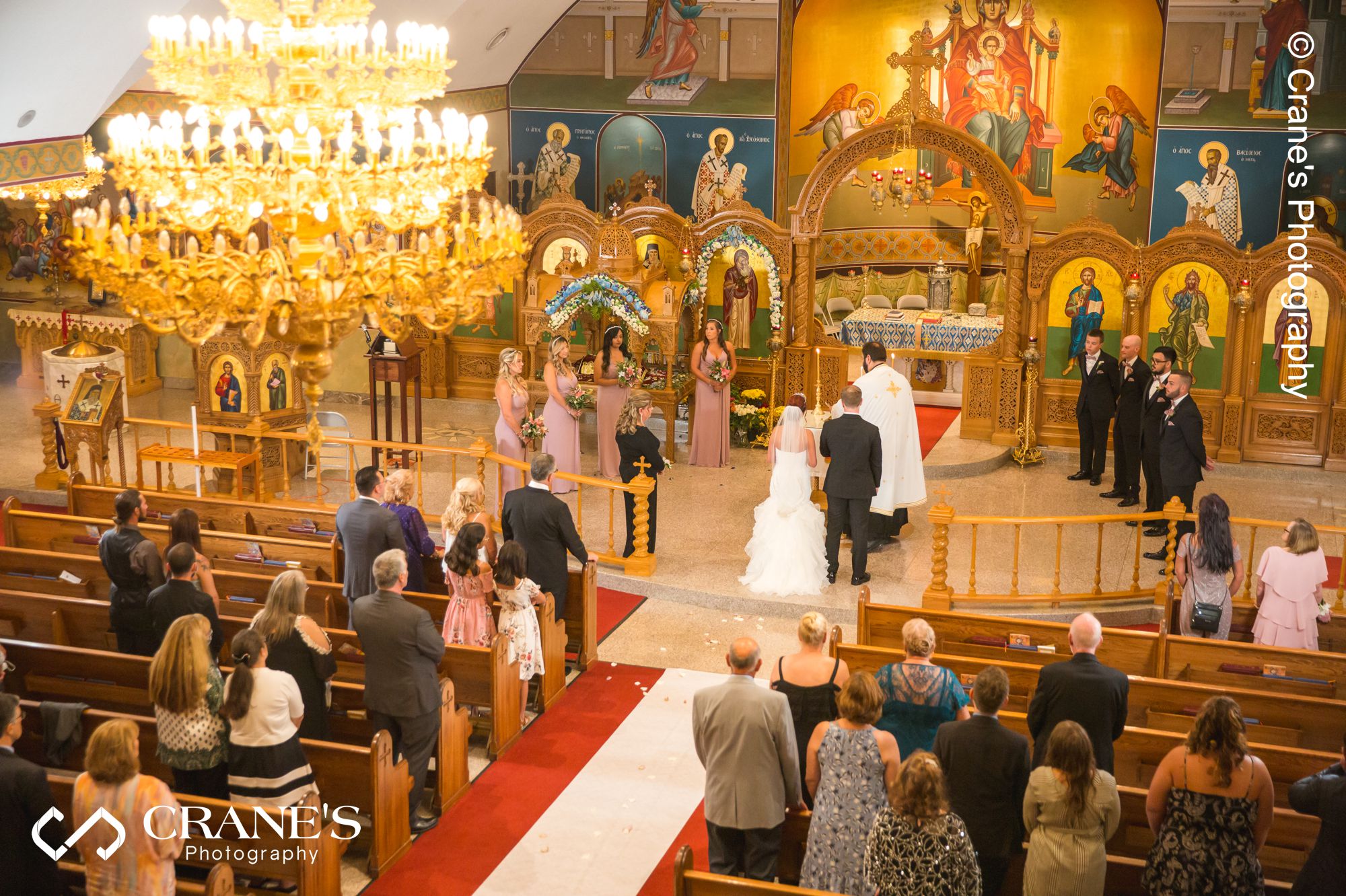 A wide angle image of a greek orthodox wedding ceremony taken from the balcony at St. Nectarios at Palatine, IL