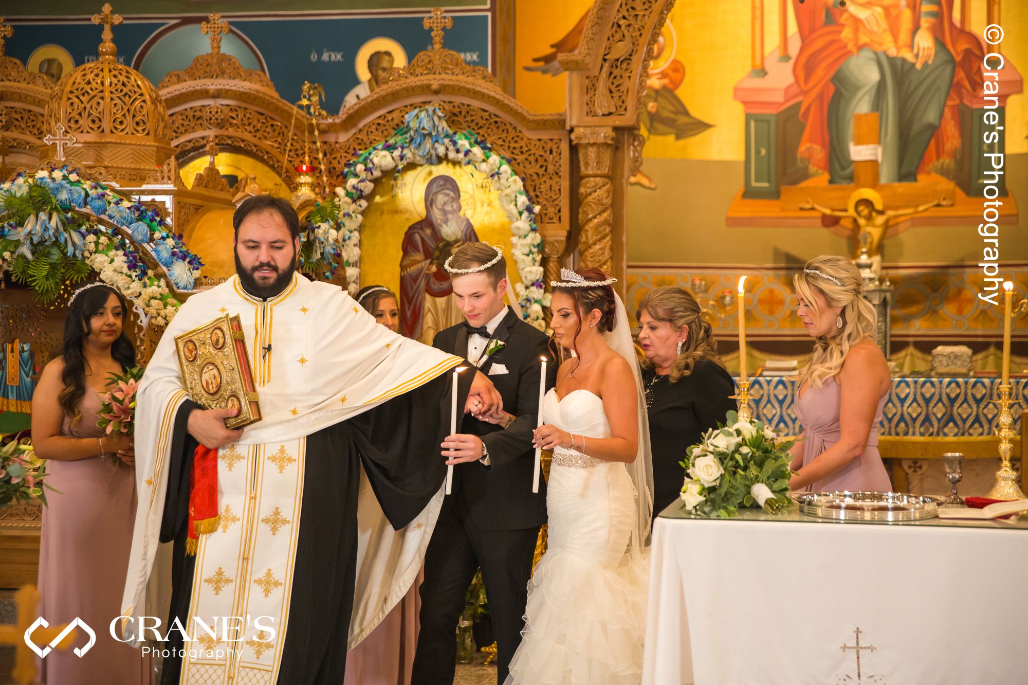 Bride and groom perform The Ceremonial Walk at the altar of St. Nectarios in Palatine during an orthodox wedding ceremony