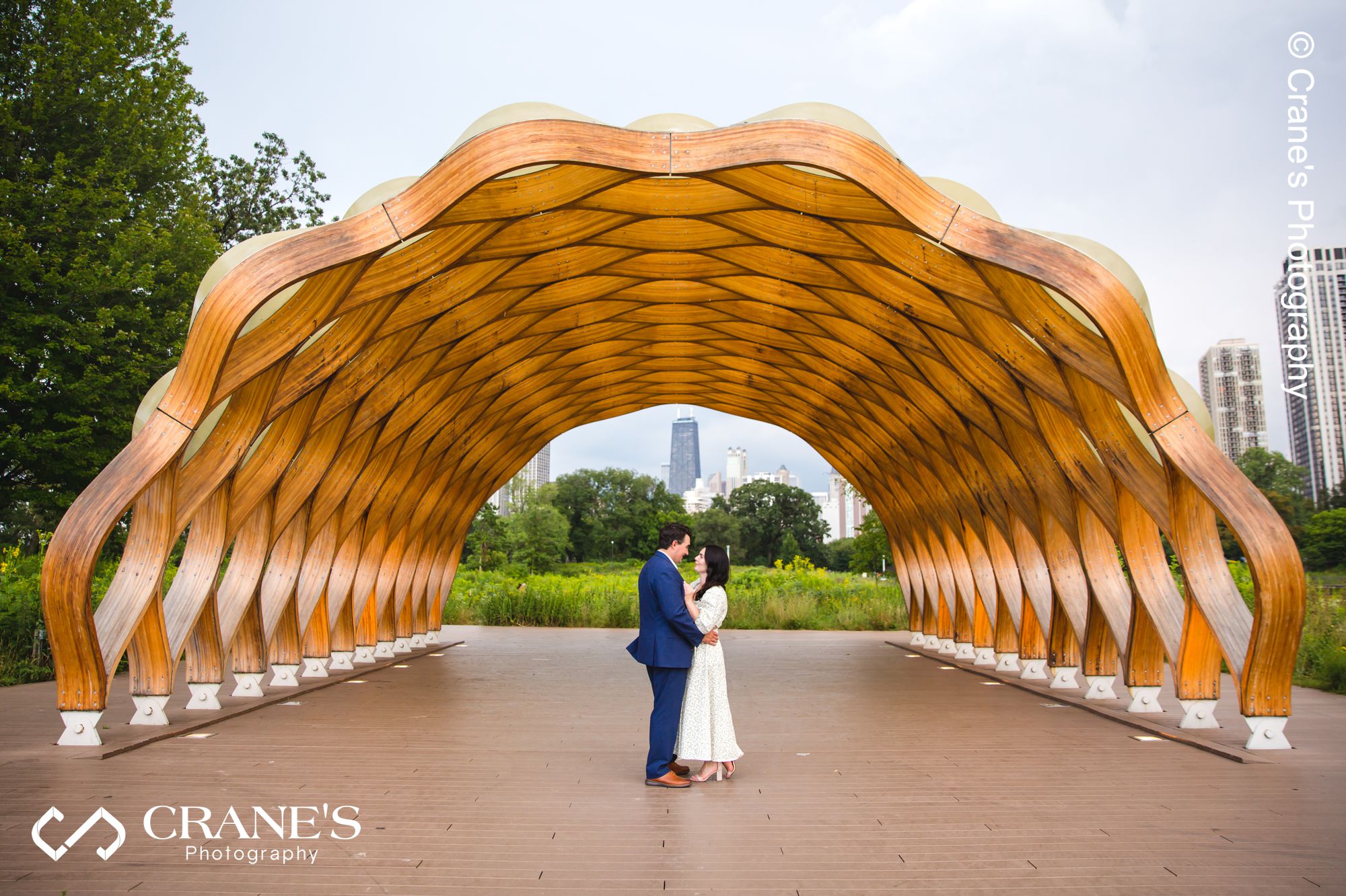 An engaged couple posing for an engagement photo in front the Honeycomb in Lincoln Park