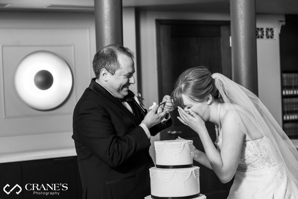 Candid moment of bride and groom cutting their wedding cake at The Library at 190 South LaSalle.
