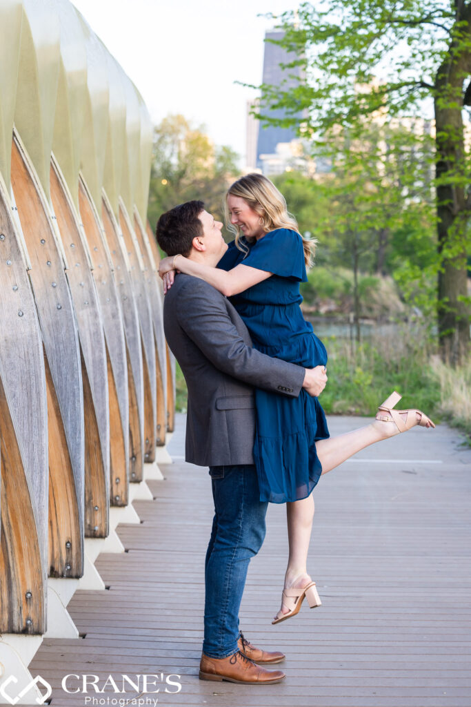 A couple wearing blue pose for an engagement photo near the Honeycomb at Lincoln Park in Chicago.