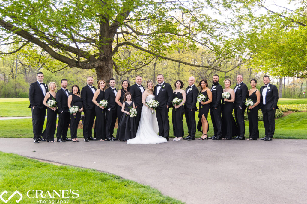 Wedding party wearing classy black and white attire posing for a photo at Royal Melbourne Country Club.