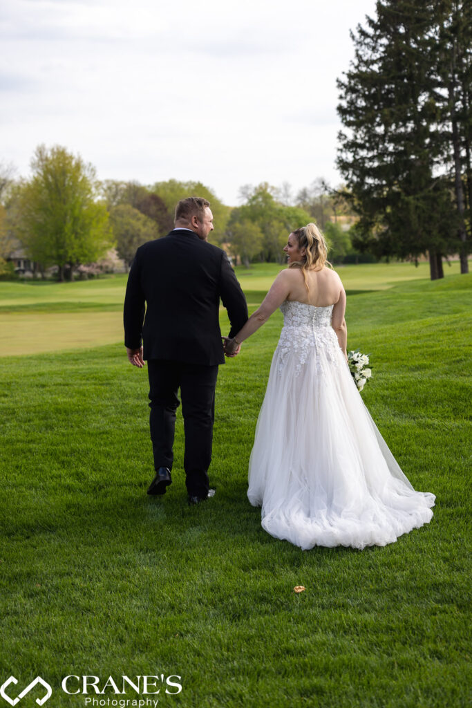 Bride and groom walking on the 18th green at Royal Melbourne Country Club.