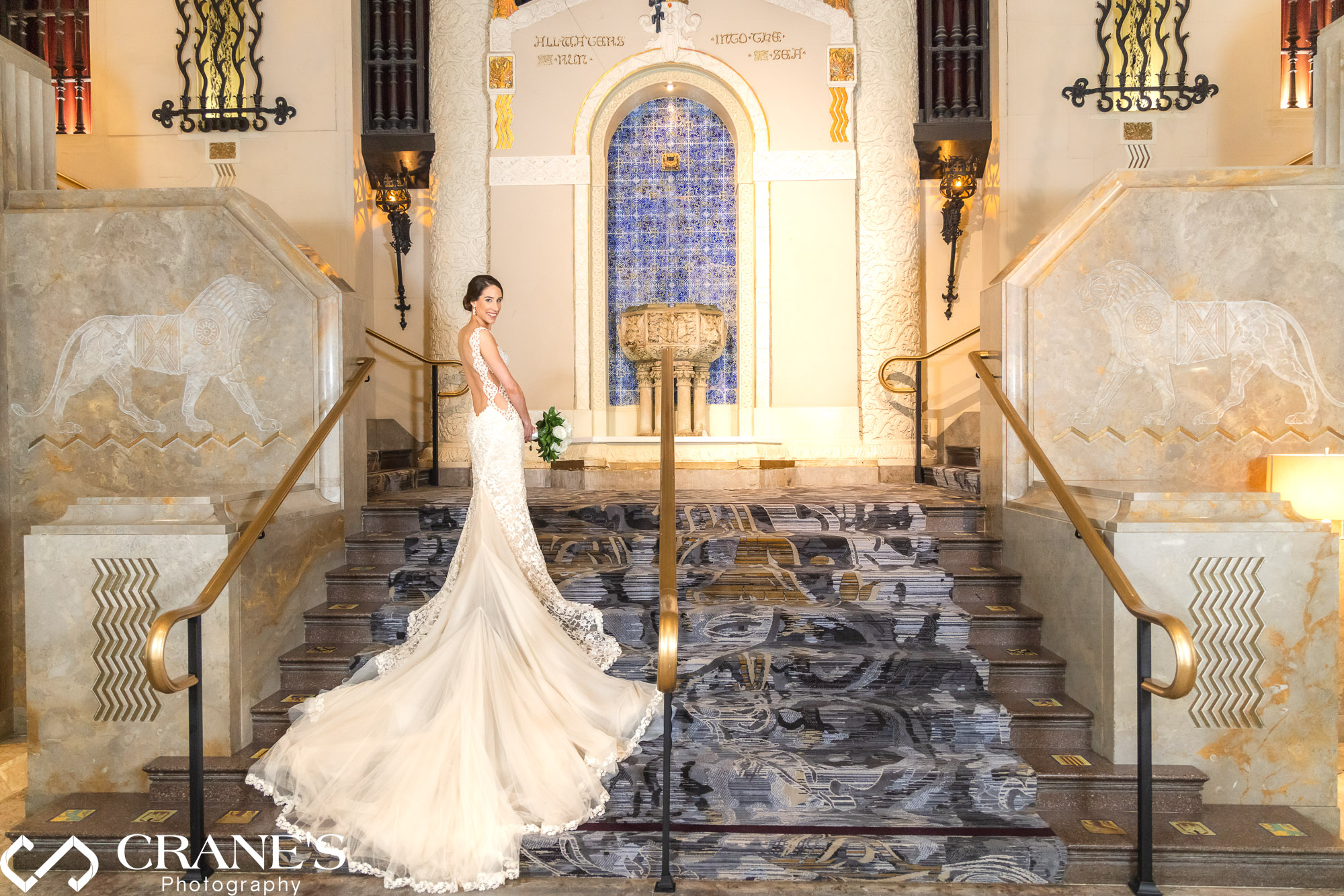 A bride wearing a designer dress is posing for a wedding portrait at the stairs at InterContinental in Chicago