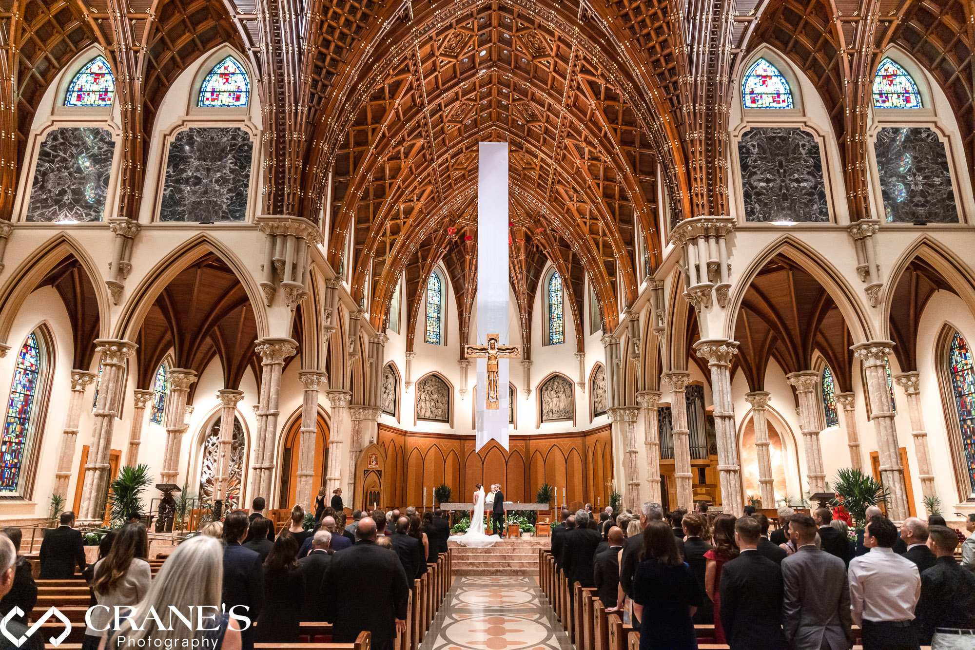A wide angle view of the altar of Holy Name Cathedral during a wedding ceremony.