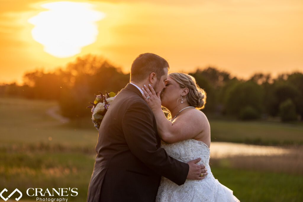 Bride and groom kiss during the golden hour on a summer day at their wedding at Makray Memorial in Barrington, IL.