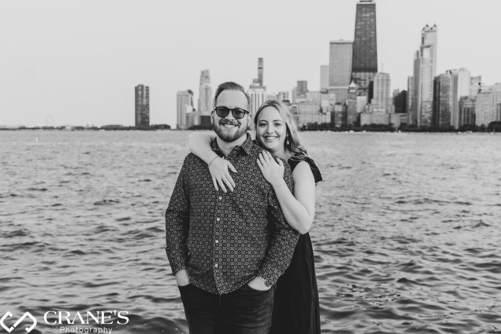 A black and white engagement image taken at The North Avenue Beach near Lincoln Park showing the Skyline of Chicago.