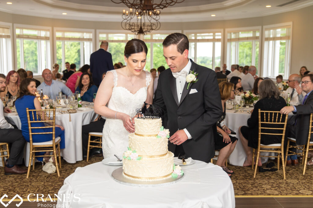 Bride and groom cutting their wedding cake at the ballroom at Royal Melbourne country club.