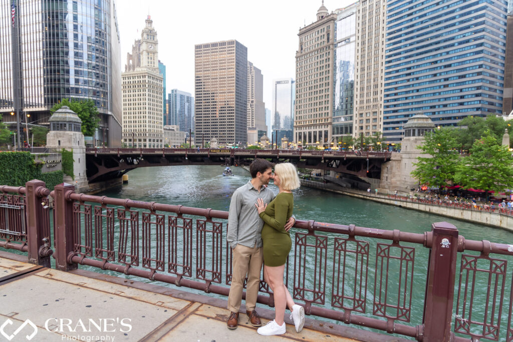 A skyline view of Chicago from a bridge showing the Riverwalk and Wrigley Building in the background.
