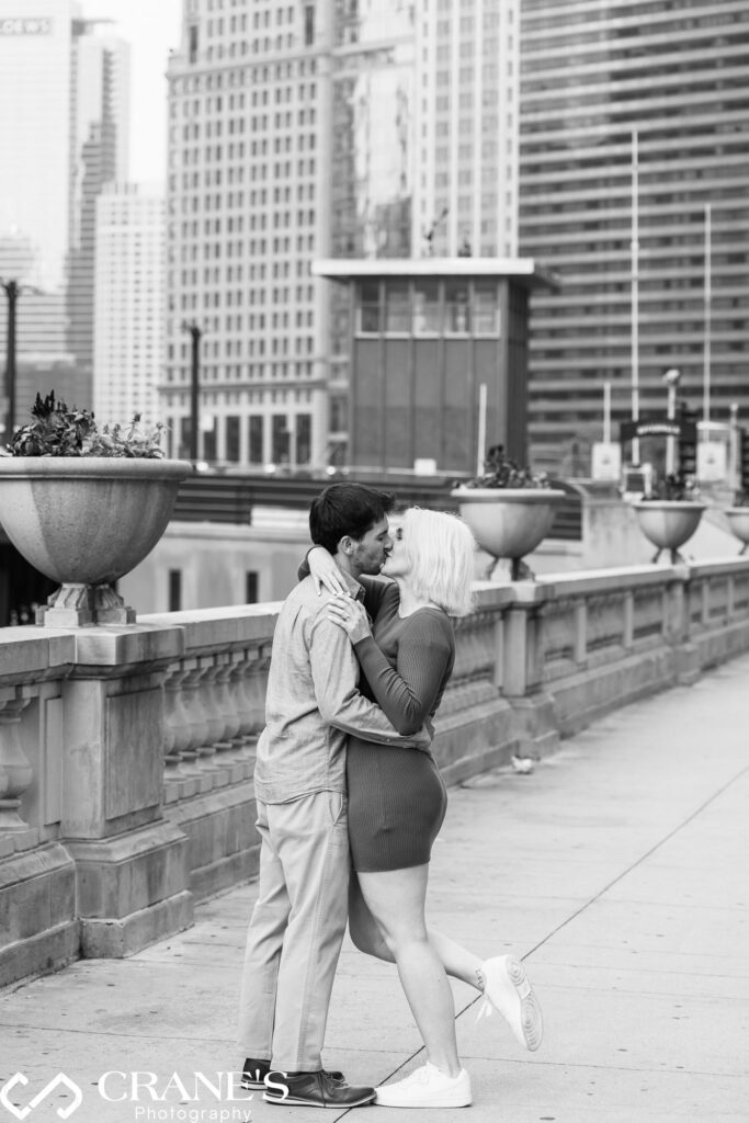 A couple kissing on Wacker Ave with a view of The Riverwalk in Chicago.