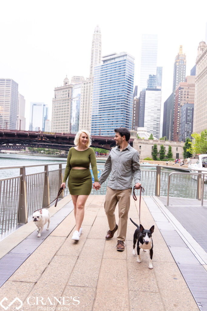 An engaged couples are walking with their dogs at the Chicago Riverwalk.