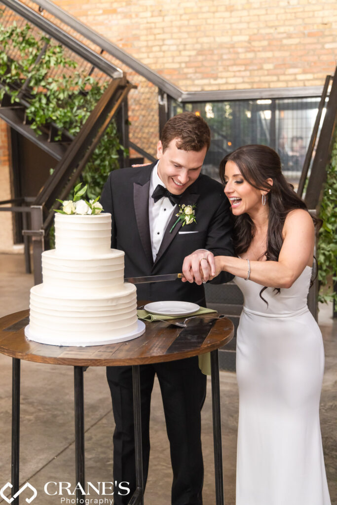 Bride and groom cut their wedding cake with the custom-designed raw staircase in the background at Fairlie.