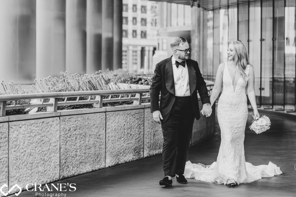 A wedding couple in elegant attire are posing for their wedding photos outside of Trump Tower.