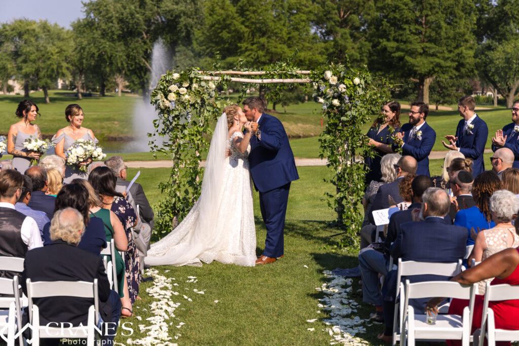 Bride and groom's first kiss as a married couple at Bloomingdale Golf Club.