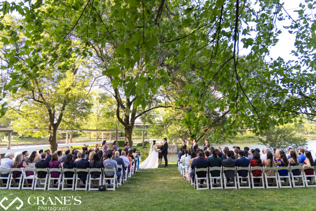 An outdoor wedding ceremony nestled amid the trees and grass by the serene lake at Hyatt Lodge.