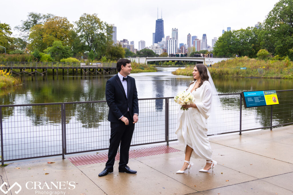 Newlyweds share a heartfelt first look near Cafe Brauer's southern pond on their wedding day.