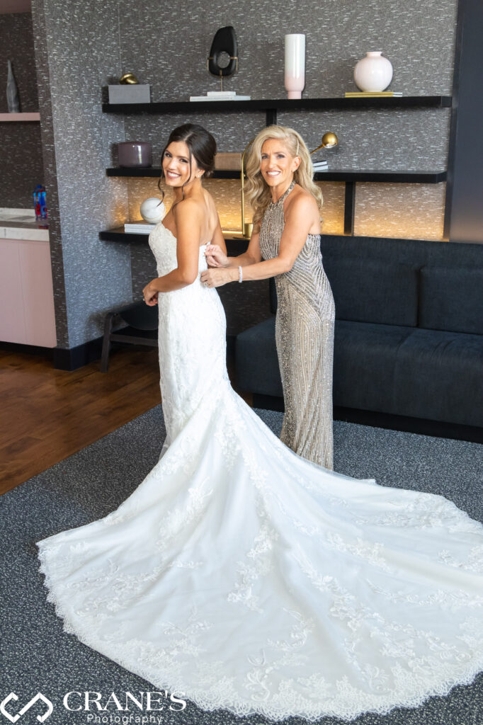 At the bridal suite in Loews Rosemont, Illinois, the mother of the bride is help her daughter in her wedding dress.