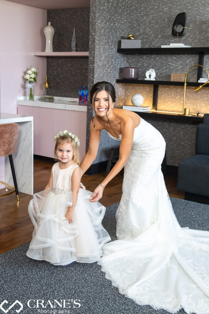 The bride and her flower girl are preparing together for a wedding reception at Loews in Rosemont.