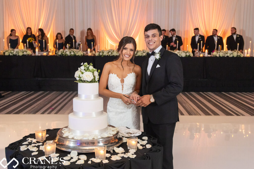 The bride and groom cut their wedding cake during a formal black-tie wedding reception at Loews Hotel in Rosemont.